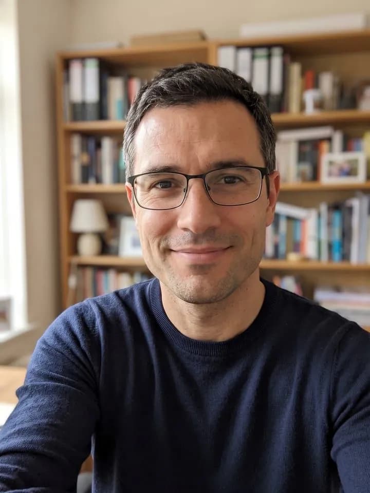 AI-generated sample input: selfie of a man with short dark hair graying at the temples, thin rectangular glasses and stubble in a navy sweater