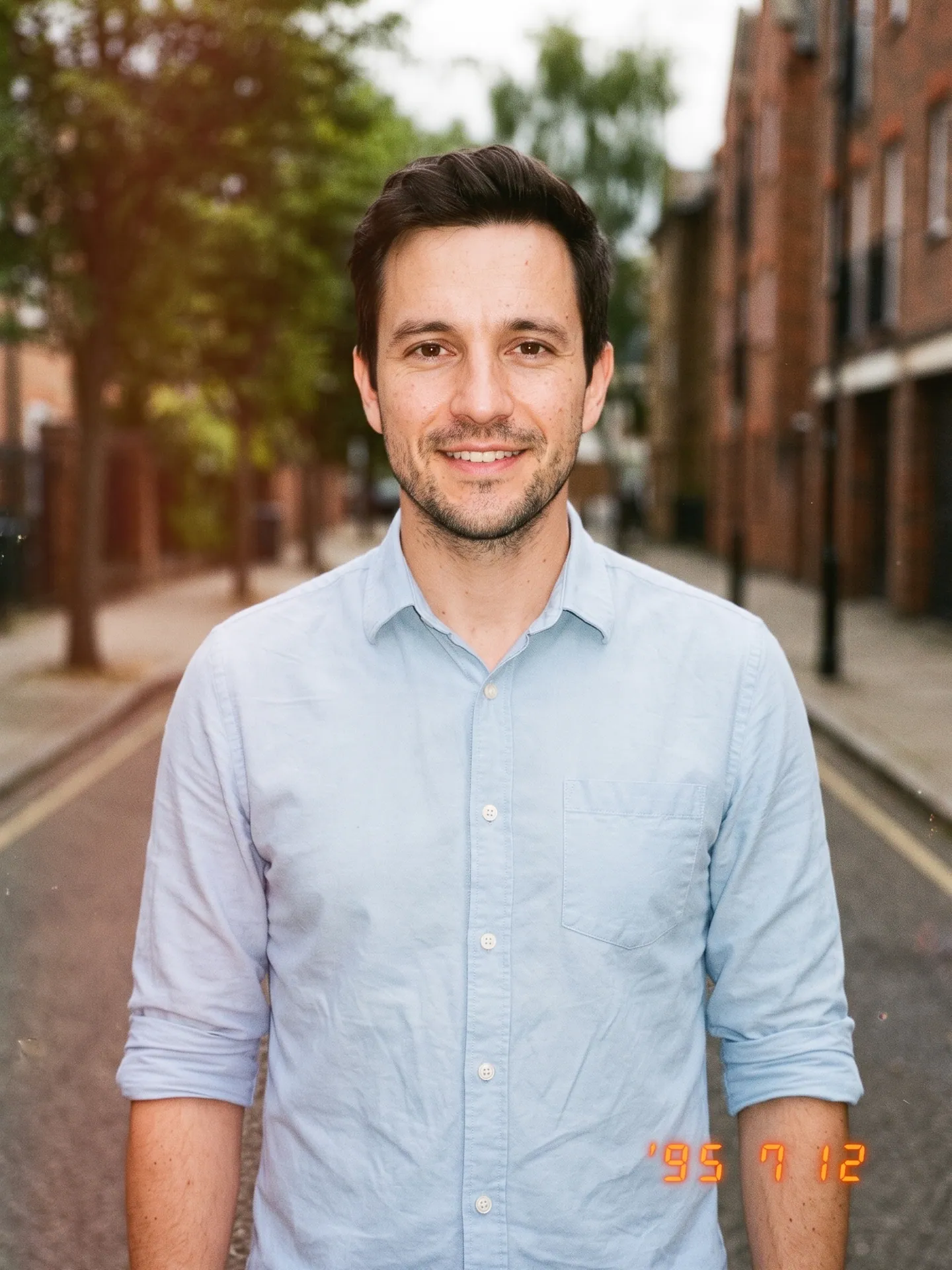 Man on a brick street in warm, grainy film color with an orange date stamp, made with the 90s Film Photo template